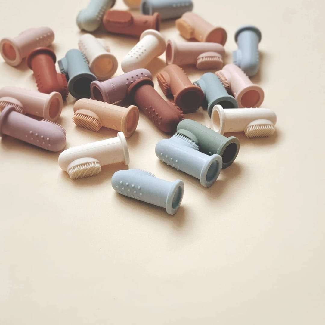 Close-up of BPA-free baby finger toothbrush on adult finger.