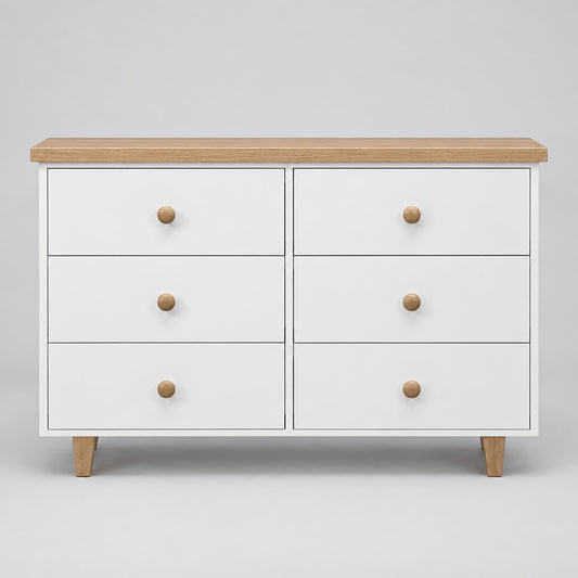 A modern 6-drawer dresser with a white painted finish, light natural oak top and legs, and round wooden knobs, shown against a neutral gray background.