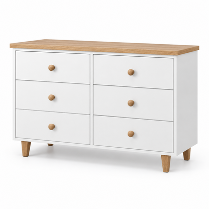 A white six-drawer dresser with a light wood top and round wooden knobs, styled with a gray basin, jewelry organizer, and small decor items against a white brick wall.