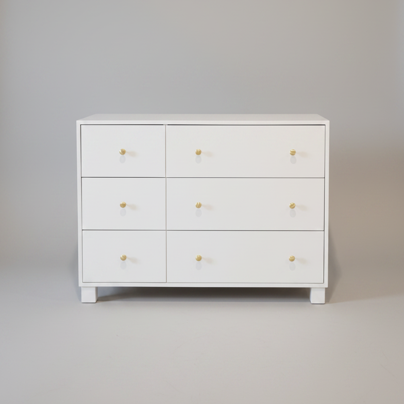 White dresser with six drawers on a plain background