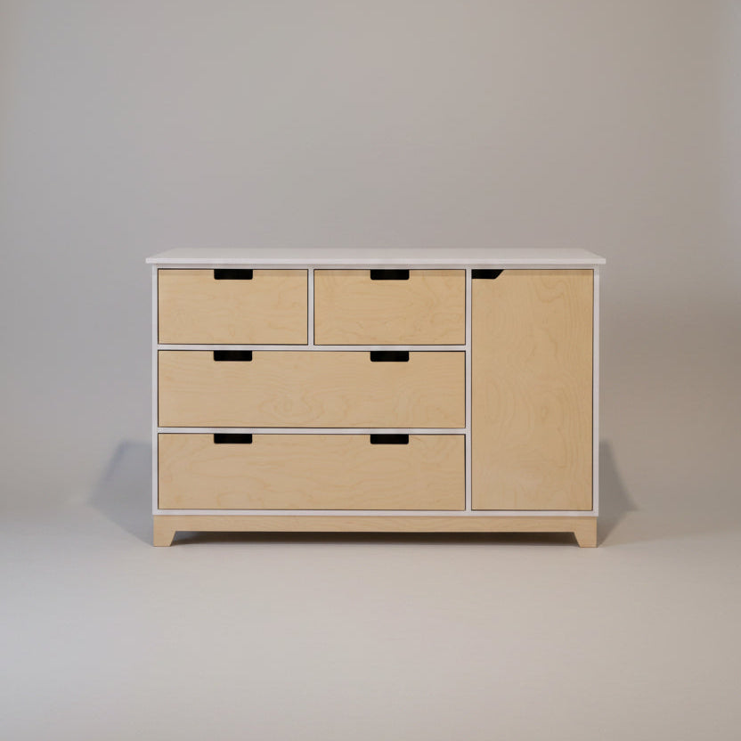 Wooden dresser with multiple drawers against a white wall