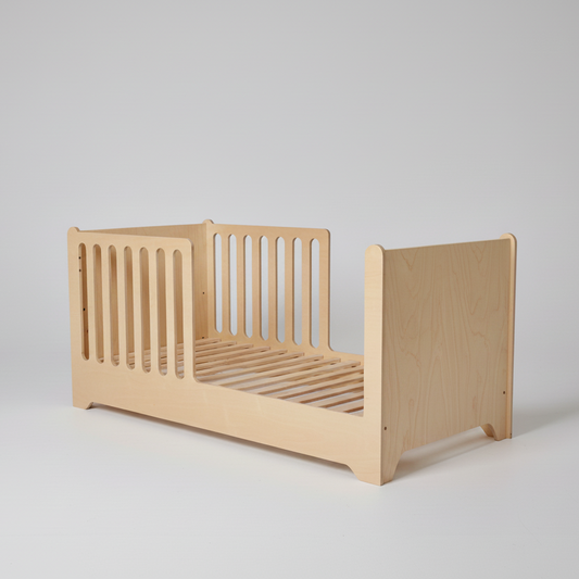 Wooden toddler bed on a plain background