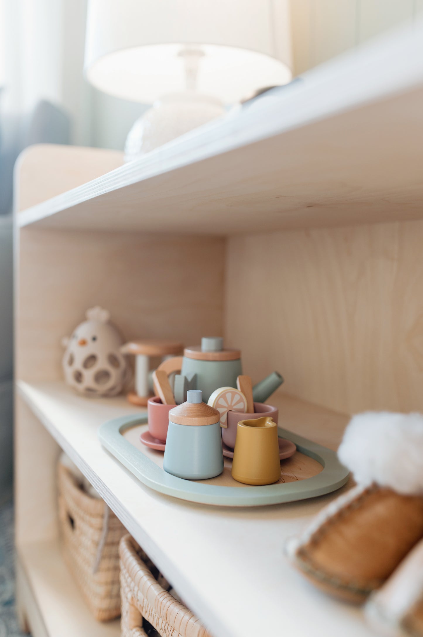 Set of colorful ceramic teapots on a shelf with a soft focus background