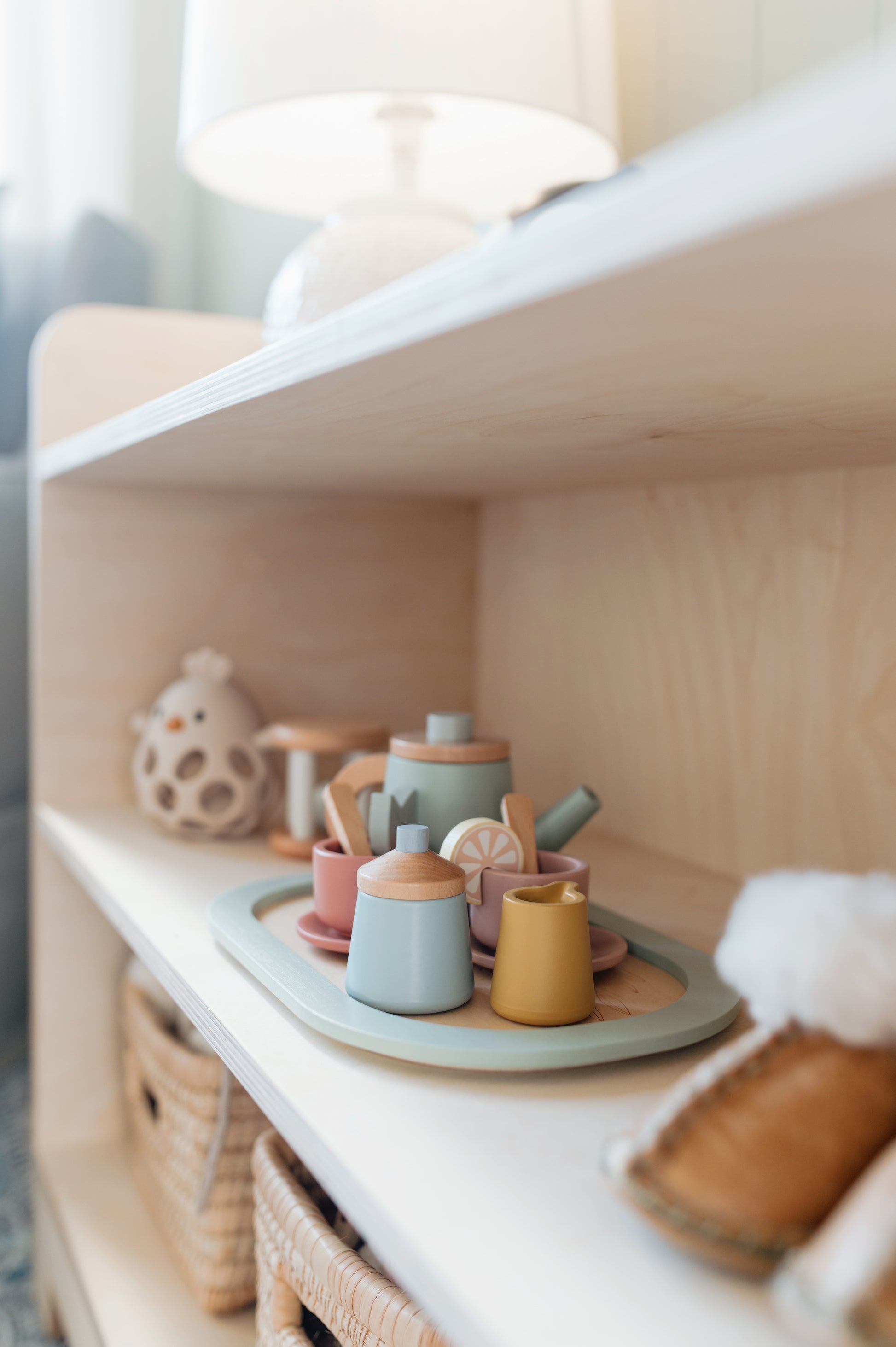Set of colorful ceramic teapots on a shelf with a soft focus background