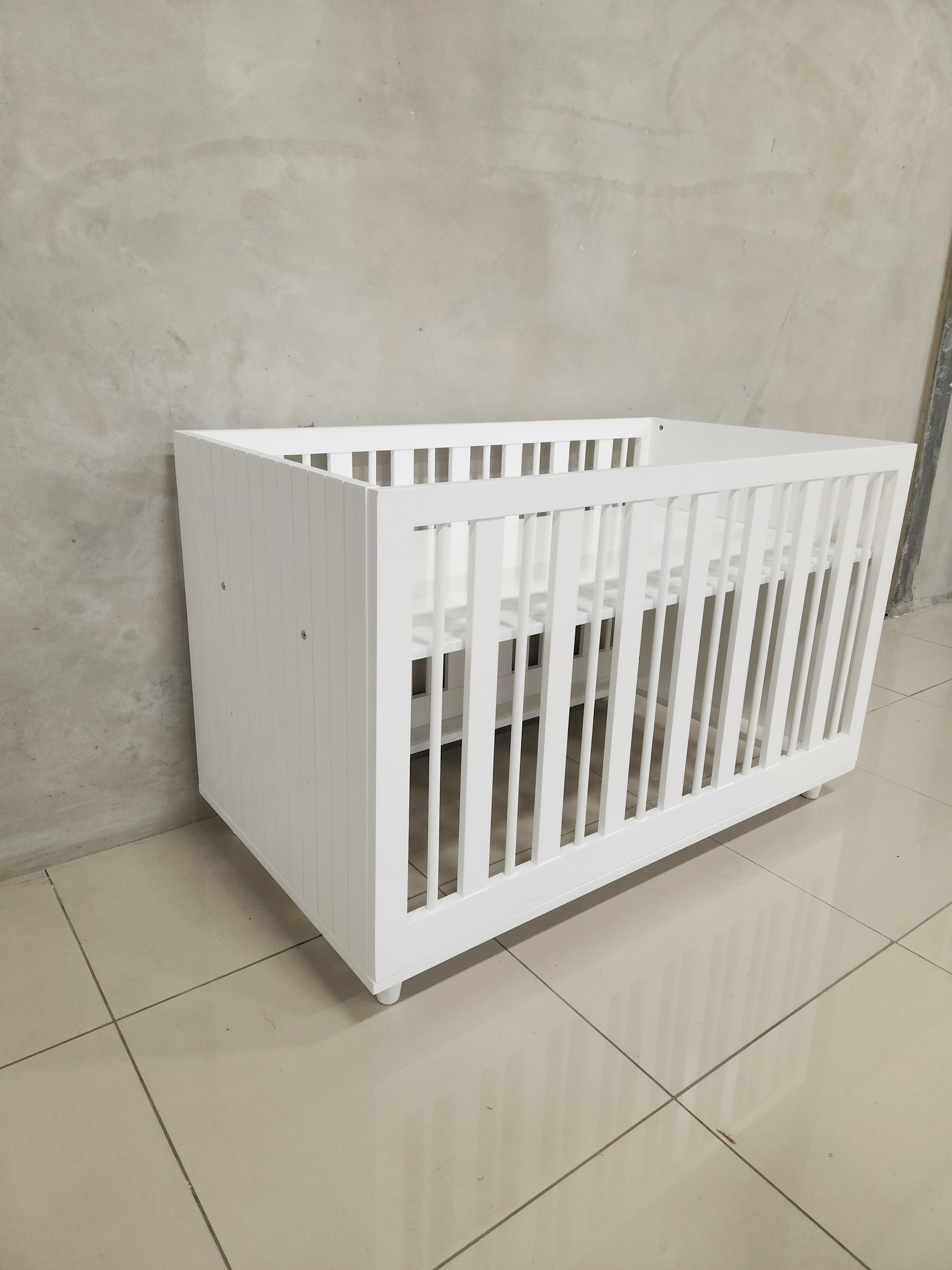 Modern white Line Cot with adjustable height settings and baby-safe materials.