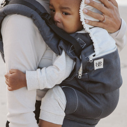 Parent carrying toddler in Ubuntu Baba Stage 2 Baby Carrier during a nature walk.