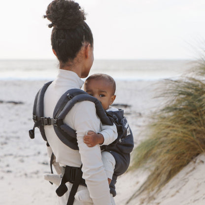Parent carrying toddler in Ubuntu Baba Stage 2 Baby Carrier during a nature walk.