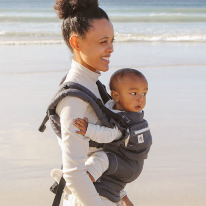 Parent carrying toddler in Ubuntu Baba Stage 2 Baby Carrier during a nature walk.