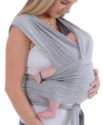 Parent wearing the SnuggleRoo Baby Carrier in the Newborn position, cradling a sleeping infant