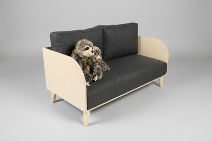 Small gray sofa with a plush toy on a plain background