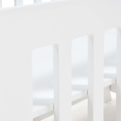 Pinkfoot Cot in white MDF styled in a modern nursery with plush bedding.