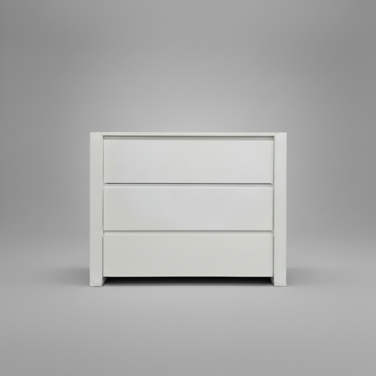 White nursery compactum with three drawers on a gray background
