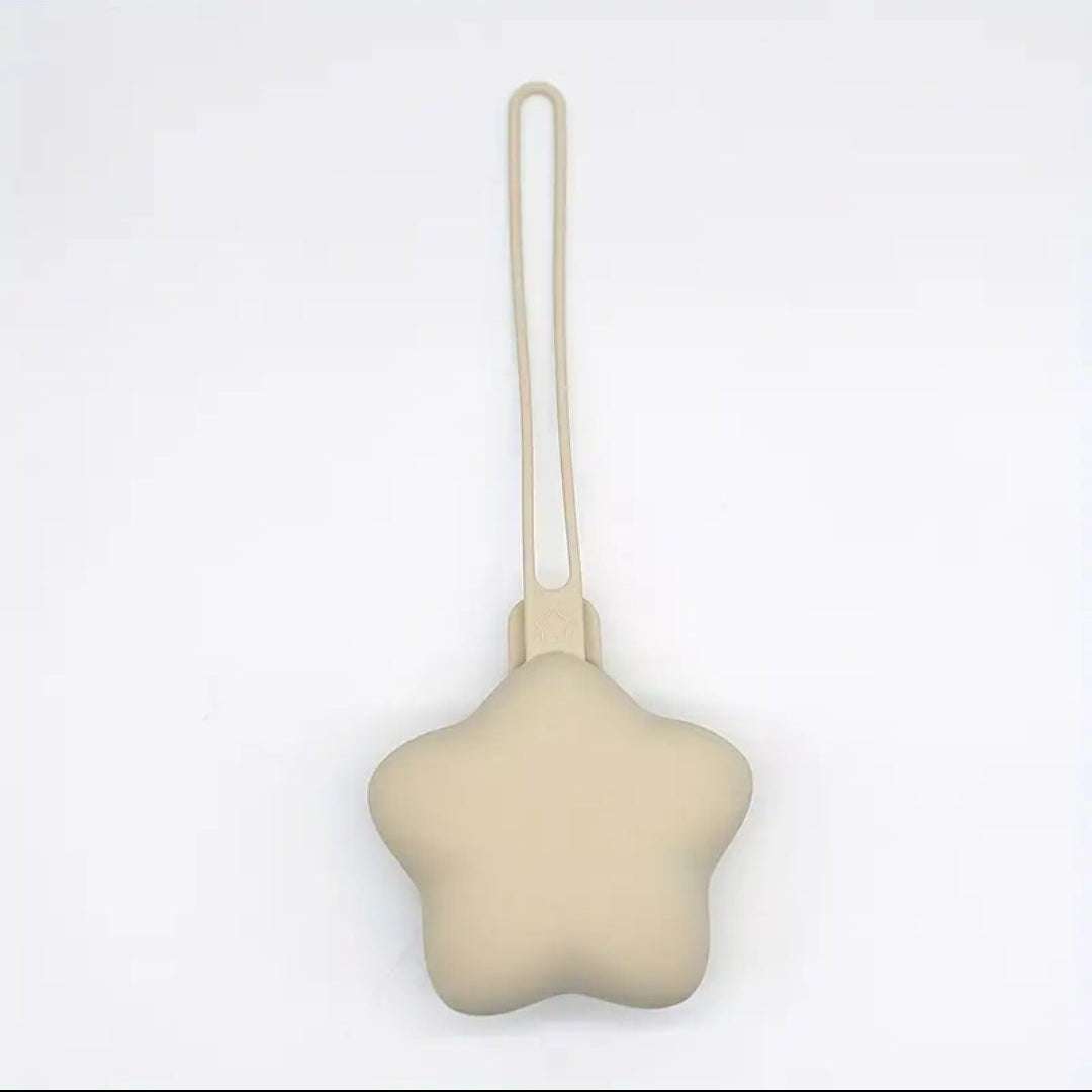 Star-shaped beige dummy holder with a string on a white background